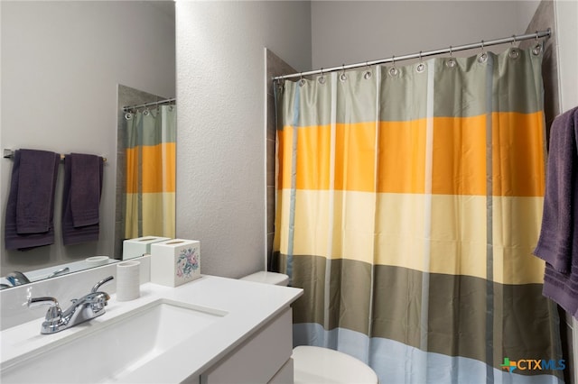 bathroom featuring vanity, toilet, and walk in shower