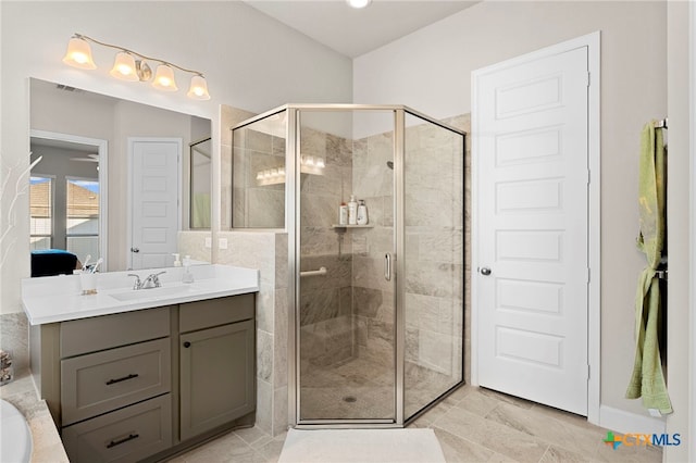 bathroom with tile patterned flooring, vanity, and walk in shower