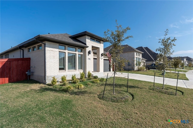 prairie-style house featuring a front yard and a garage