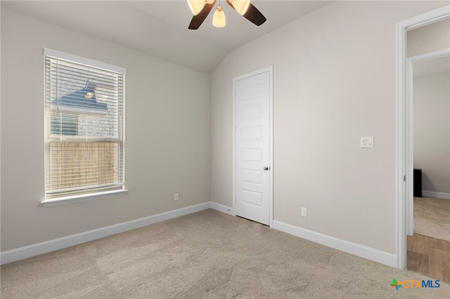 unfurnished bedroom featuring ceiling fan, light colored carpet, and vaulted ceiling