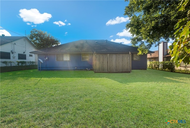 rear view of property featuring a lawn