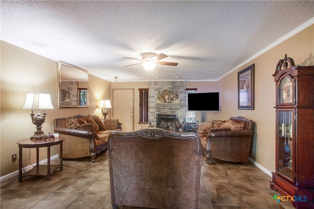 tiled living room with ceiling fan, a textured ceiling, a large fireplace, and crown molding