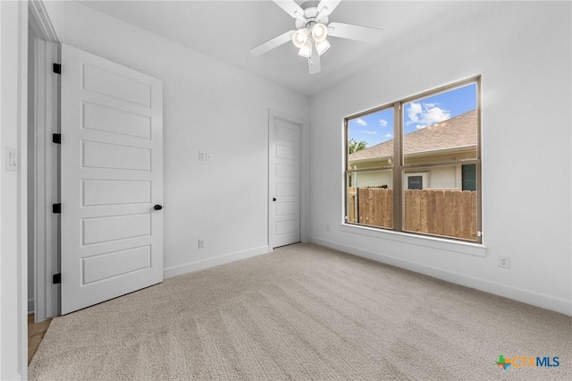 unfurnished room featuring carpet floors, a ceiling fan, and baseboards