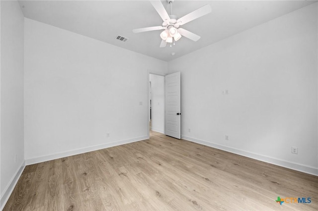 spare room with a ceiling fan, baseboards, visible vents, and light wood finished floors