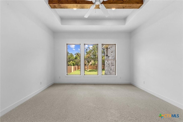 unfurnished room featuring light carpet, ceiling fan, baseboards, and a raised ceiling