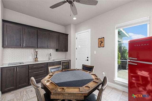 dining room featuring a wealth of natural light, ceiling fan, sink, and wine cooler