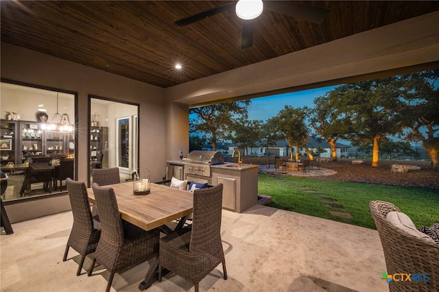 patio terrace at dusk featuring a grill, a yard, sink, area for grilling, and ceiling fan