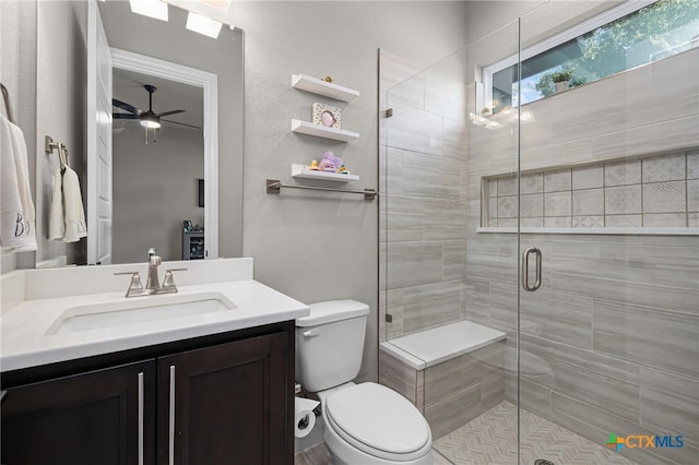 bathroom with ceiling fan, a shower with shower door, vanity, and toilet