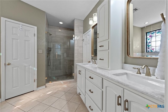 bathroom with double vanity, a stall shower, tile patterned flooring, and a sink