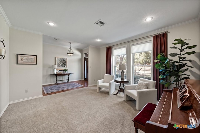 sitting room featuring baseboards, visible vents, ornamental molding, and carpet flooring