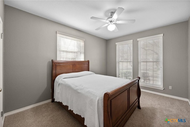 bedroom with light carpet, ceiling fan, and baseboards