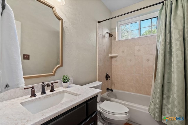 full bathroom featuring toilet, shower / bath combo, vanity, and a textured wall