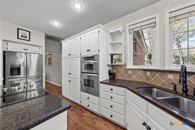 kitchen with open shelves, tasteful backsplash, appliances with stainless steel finishes, white cabinets, and a sink