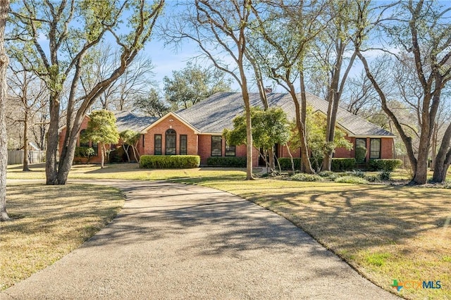 ranch-style house with brick siding and a front yard