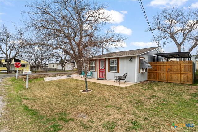 exterior space featuring a patio area, fence, and a front lawn