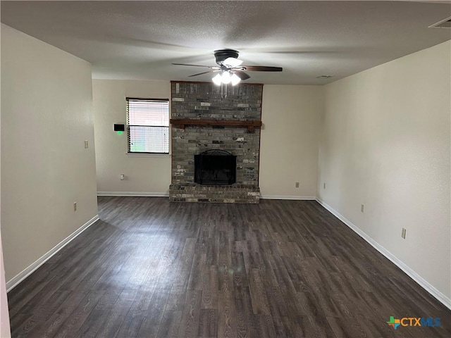 unfurnished living room featuring a ceiling fan, visible vents, a fireplace, dark wood finished floors, and baseboards