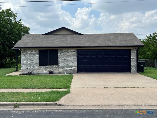 view of front of property featuring brick siding, driveway, a front lawn, and a garage