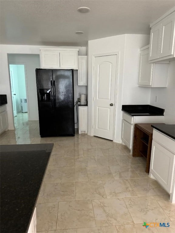 kitchen with white cabinets and black fridge