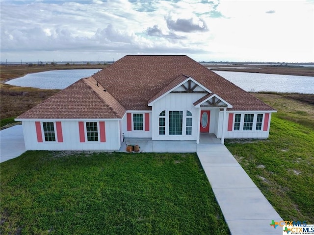 single story home with a water view and a front yard