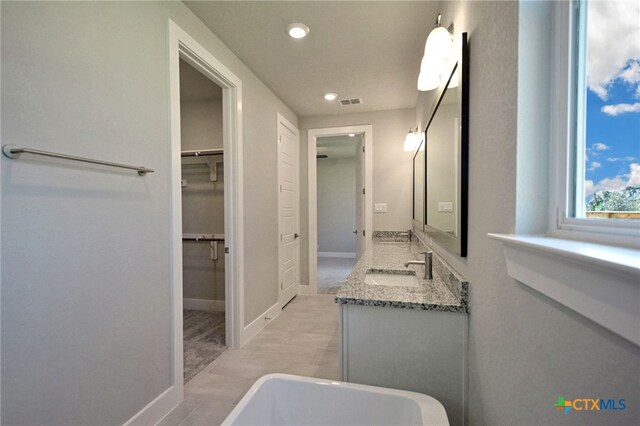 full bathroom featuring a spacious closet, visible vents, baseboards, recessed lighting, and vanity