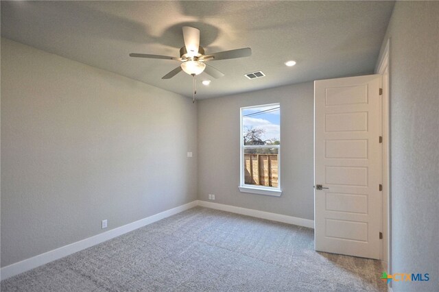 carpeted spare room featuring visible vents, recessed lighting, a ceiling fan, and baseboards