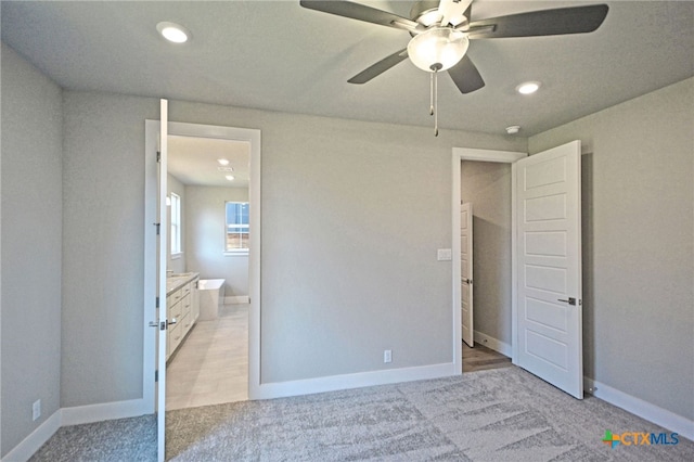 unfurnished bedroom with recessed lighting, connected bathroom, baseboards, and light colored carpet