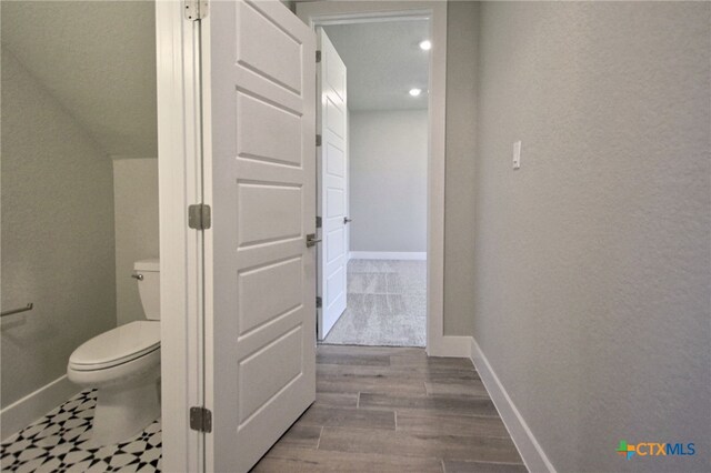 bathroom featuring toilet, baseboards, and wood finished floors