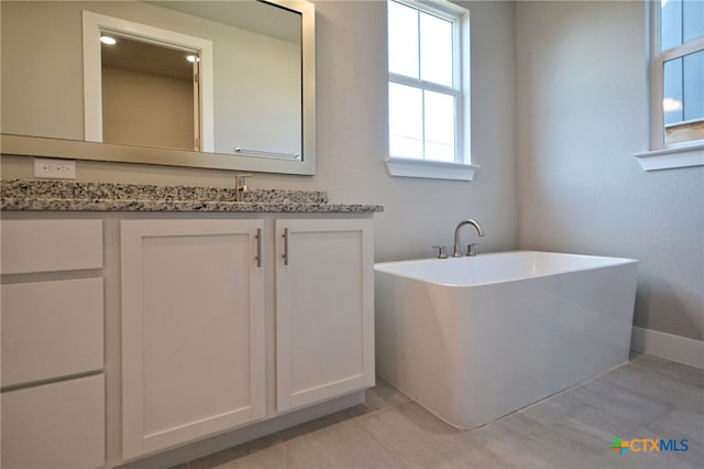 full bath featuring vanity and a freestanding tub