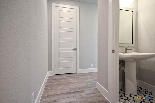 bathroom with a sink, baseboards, and wood finished floors