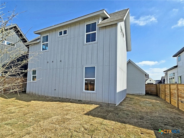 rear view of property featuring fence and board and batten siding