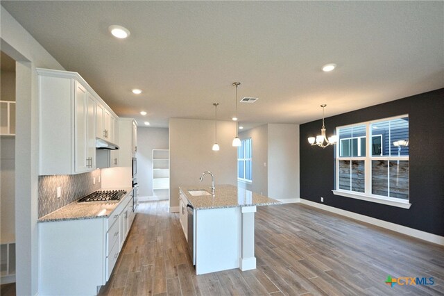 kitchen with visible vents, a sink, under cabinet range hood, white cabinetry, and stainless steel appliances