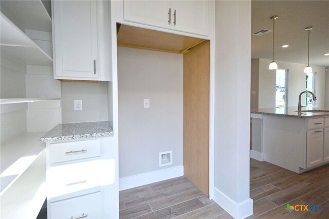 kitchen with light stone counters, visible vents, and wood tiled floor