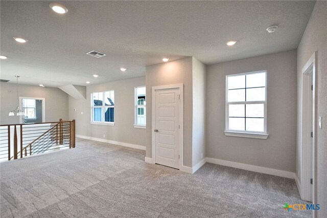 unfurnished room featuring visible vents, carpet flooring, and baseboards