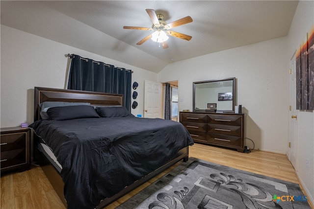 bedroom with light hardwood / wood-style floors, vaulted ceiling, and ceiling fan