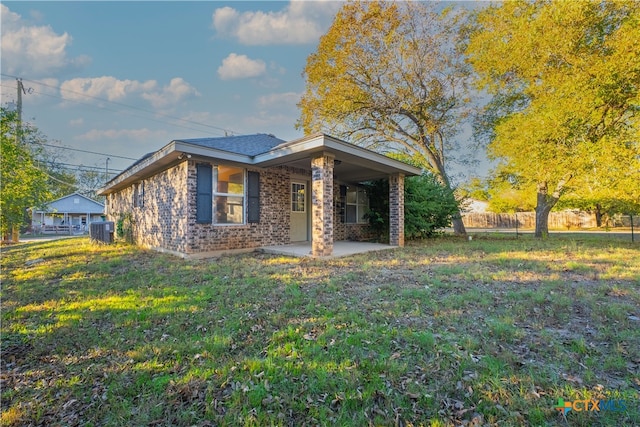 view of front facade featuring a front yard, a patio, and cooling unit