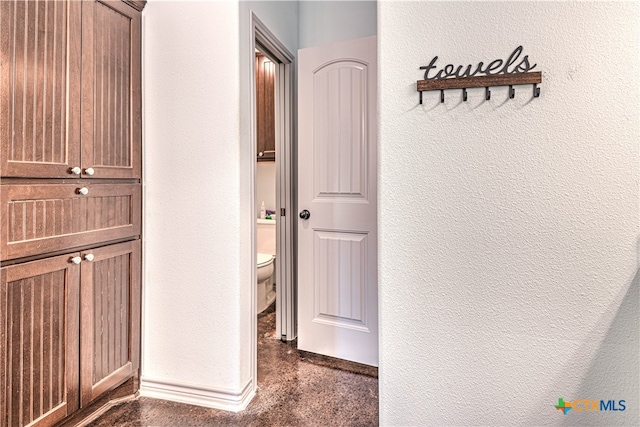 hallway with dark colored carpet