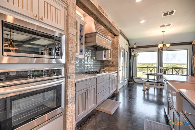 kitchen with gray cabinets, stainless steel appliances, beamed ceiling, and decorative backsplash