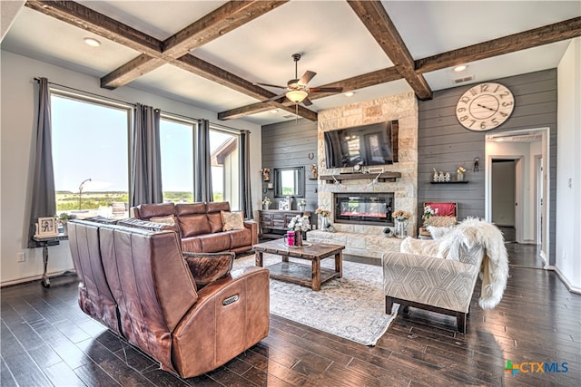 living room with dark wood-type flooring, coffered ceiling, a stone fireplace, and wooden walls