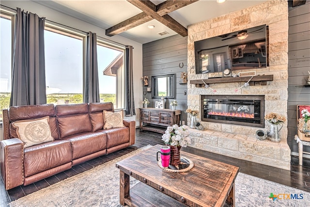 living room featuring dark wood-type flooring, wooden walls, coffered ceiling, beam ceiling, and a fireplace