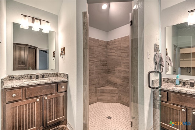 bathroom with a shower with shower door, vanity, and tile patterned floors