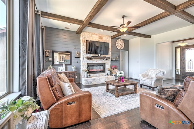 living room with a stone fireplace, dark hardwood / wood-style flooring, beam ceiling, and coffered ceiling