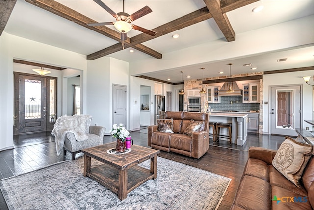 living room featuring dark wood-type flooring, ceiling fan, beam ceiling, and coffered ceiling