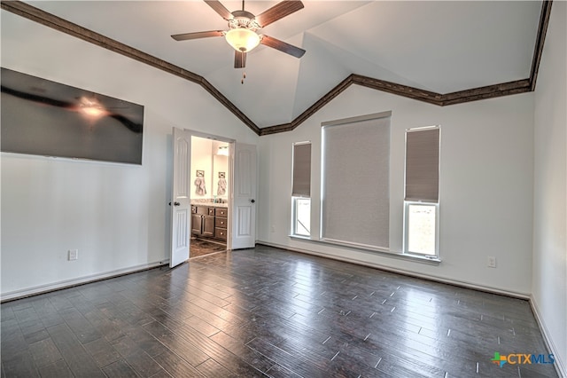 empty room with dark hardwood / wood-style flooring, ornamental molding, vaulted ceiling, and ceiling fan