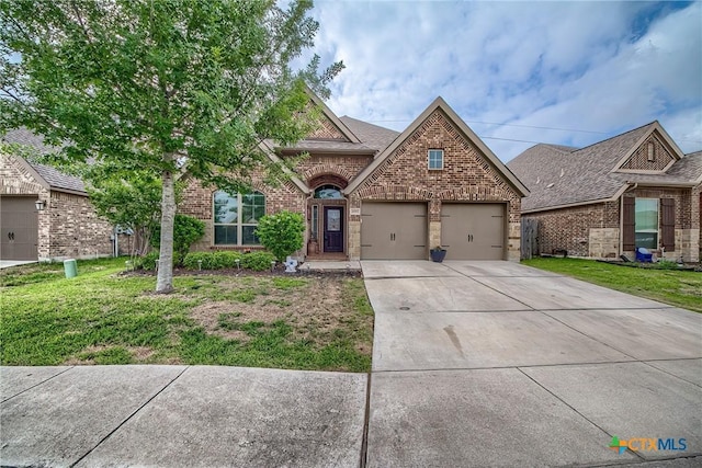 view of front of home with a garage, driveway, a front lawn, and brick siding