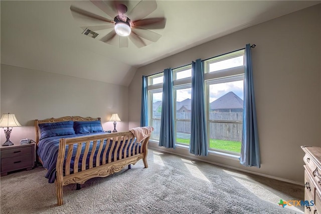 carpeted bedroom with visible vents, a ceiling fan, baseboards, and lofted ceiling