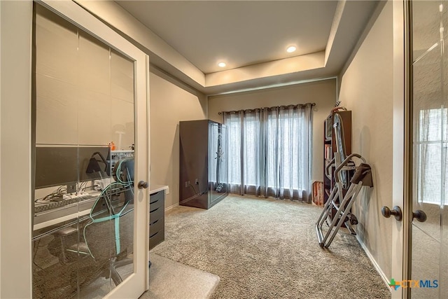 interior space with french doors, a raised ceiling, carpet flooring, and recessed lighting
