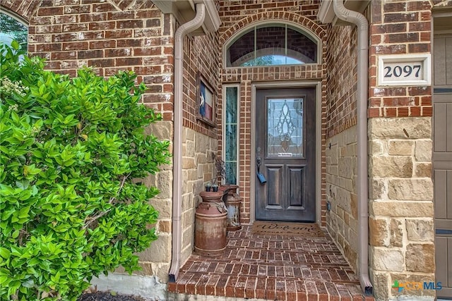 view of exterior entry with brick siding