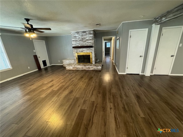 unfurnished living room with ornamental molding, ceiling fan, dark hardwood / wood-style floors, and a brick fireplace