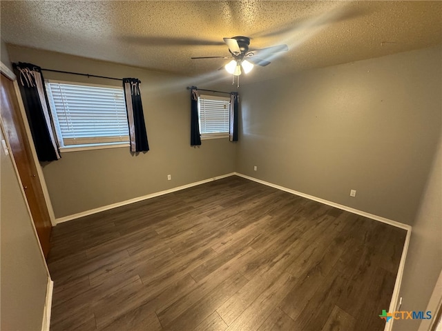 unfurnished room featuring dark wood-type flooring, ceiling fan, and a textured ceiling