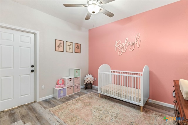 312 Holly Ave, Luling, TX 78648 - bedroom with wood finished floors, a nursery area, and ceiling fan